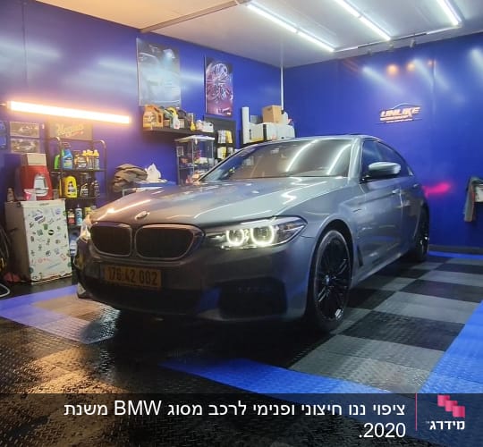 רכב אפור בחדר דיטיילינג עם תאורה חזקה